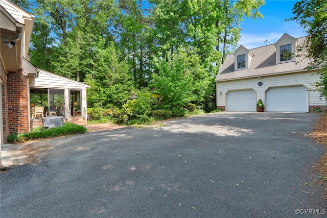 7290 Hill View Dr, Mechanicsville, VA 23111 - view of home's exterior featuring a garage, central air condition unit, brick siding, and asphalt driveway