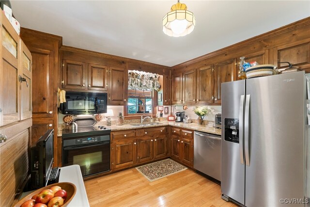 7290 Hill View Dr, Mechanicsville, VA 23111 - kitchen with black appliances, light wood-style flooring, a sink, and light stone countertops