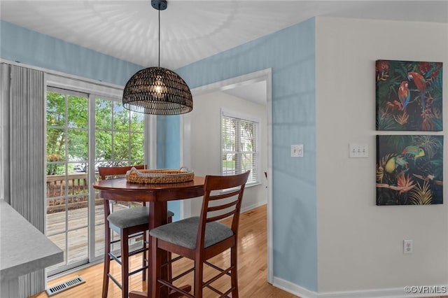 dining space with baseboards and light wood-style floors