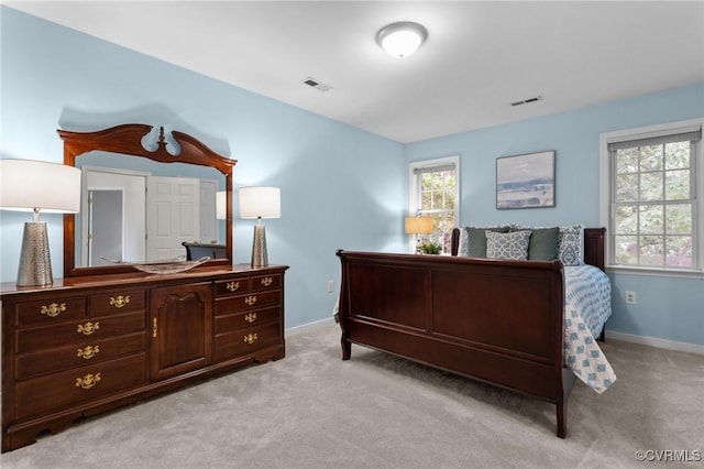 bedroom with baseboards and light carpet