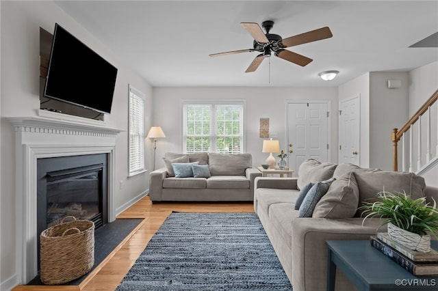 11441 Alder Glen Way, Glen Allen, VA 23059 - living room with stairs, light wood-type flooring, a ceiling fan, a fireplace with flush hearth, and baseboards