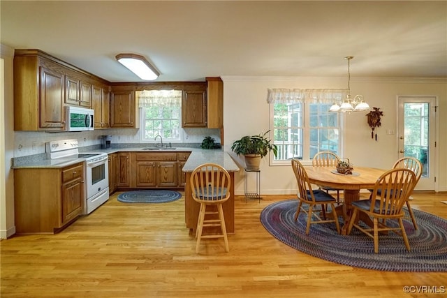 4329 Stebbins St, Chester, VA 23831 - kitchen featuring white appliances, a sink, brown cabinetry, a chandelier, and light wood-type flooring