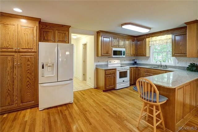 4329 Stebbins St, Chester, VA 23831 - kitchen with white appliances, a sink, brown cabinetry, a peninsula, and light wood-style floors