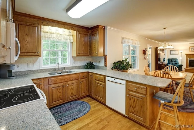 4329 Stebbins St, Chester, VA 23831 - kitchen with white appliances, a peninsula, light countertops, a breakfast bar, and brown cabinetry