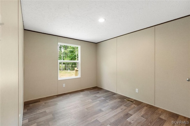 15011 Elm Cottage Rd, Amelia Courthouse, VA 23002 - empty room featuring wood finished floors, a textured ceiling, and ornamental molding