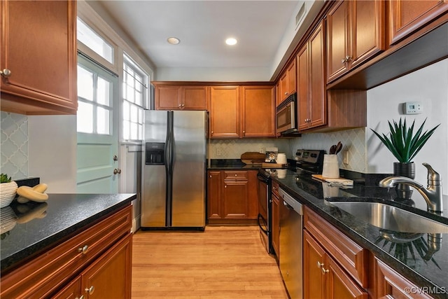 601 Roseneath Rd Unit U11, Richmond, VA 23221 - kitchen featuring appliances with stainless steel finishes, a sink, light wood-style floors, decorative backsplash, and dark stone countertops