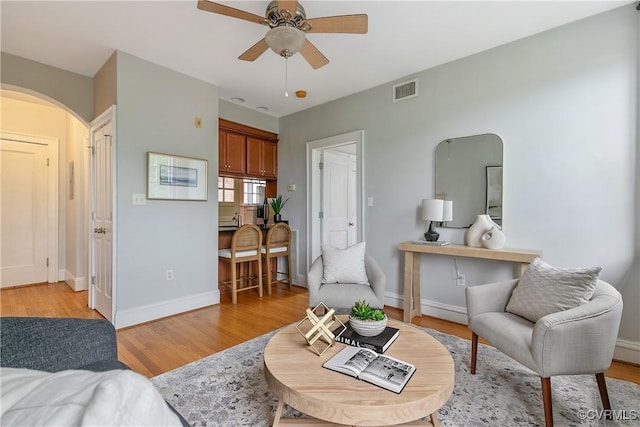 601 Roseneath Rd Unit U11, Richmond, VA 23221 - living room featuring arched walkways, ceiling fan, light wood finished floors, and baseboards