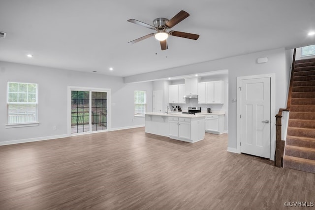 8136 Fedora Dr, Chesterfield, VA 23838 - unfurnished living room with light wood finished floors, stairway, baseboards, ceiling fan, and plenty of natural light