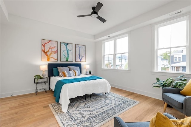 bedroom featuring baseboards, light wood finished floors, and a ceiling fan