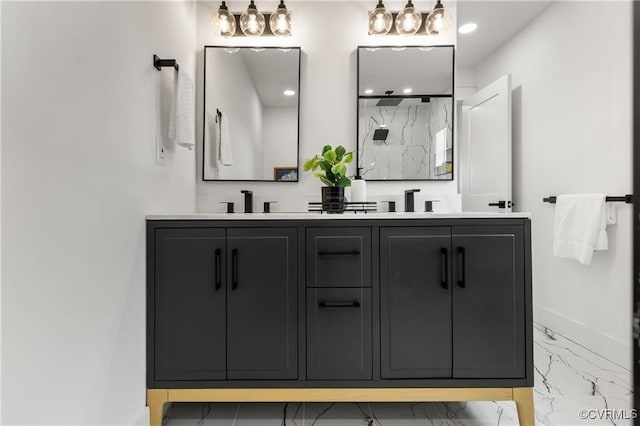 bathroom with marble look tiles, baseboards, a marble finish shower, and double vanity