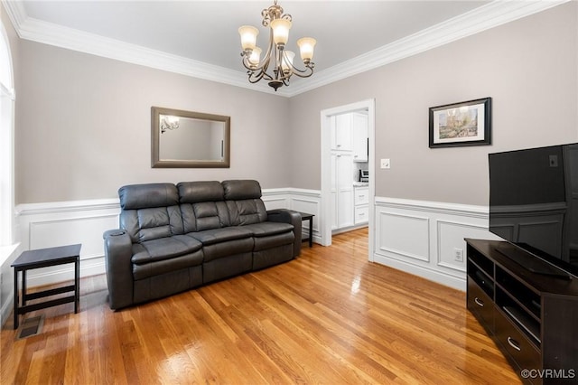 8413 Chandon Ct, Chesterfield, VA 23838 - living area featuring ornamental molding, a chandelier, light wood finished floors, wainscoting, and a decorative wall