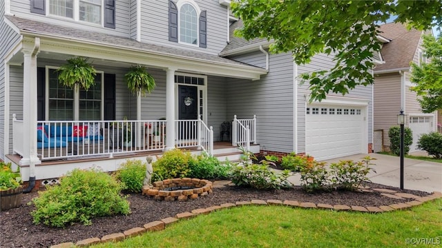 view of front of home with covered porch, concrete driveway, and a garage