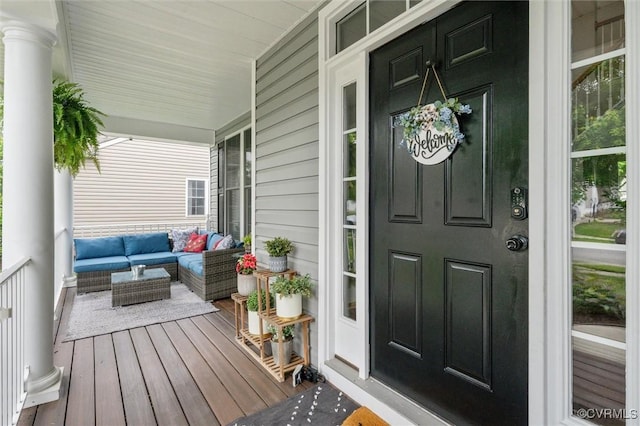 view of exterior entry featuring covered porch and outdoor lounge area