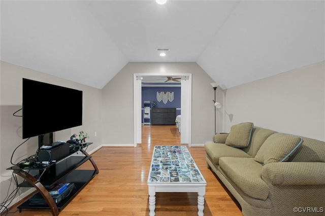 living area with wood finished floors, vaulted ceiling, and baseboards