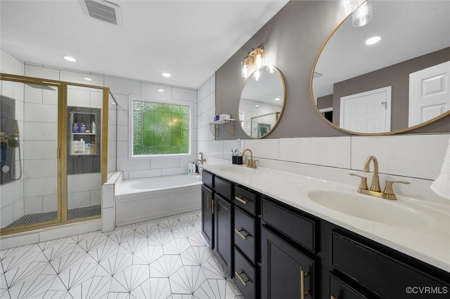 bathroom with a shower stall, a bath, double vanity, tile walls, and tile patterned floors