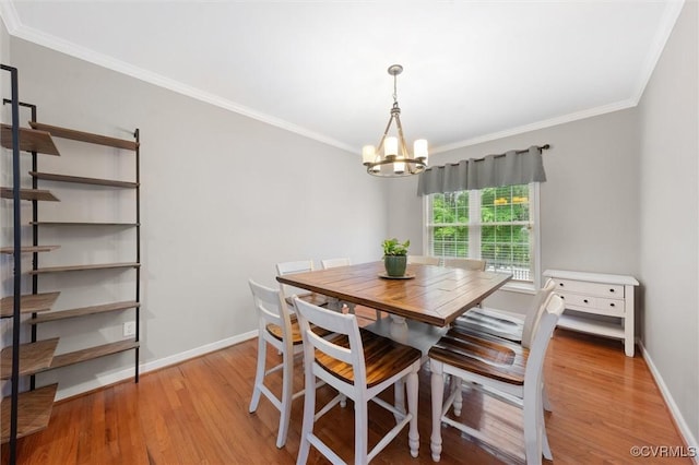 dining area featuring a chandelier, light wood finished floors, ornamental molding, and baseboards