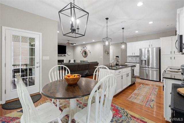 dining area featuring light wood-style floors, a ceiling fan, recessed lighting, and a chandelier