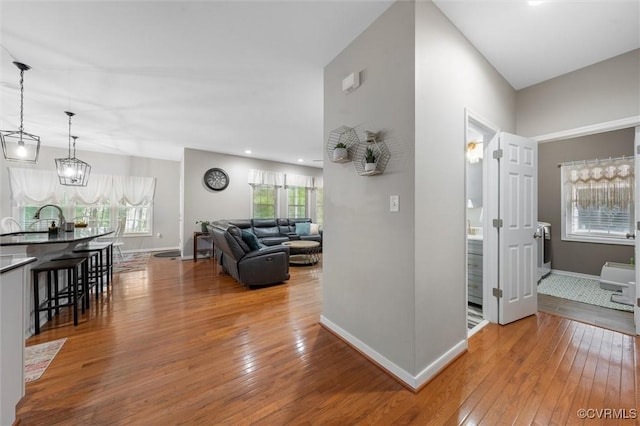 living room with wood-type flooring, baseboards, and a chandelier