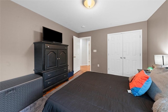 bedroom with wood finished floors and a closet