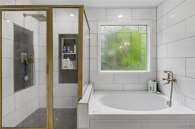 full bath featuring a bath and a shower stall