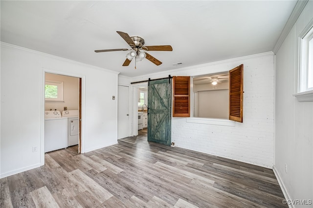 27 Medlock Rd, Sandston, VA 23150 - empty room featuring separate washer and dryer, ceiling fan, a barn door, crown molding, and wood finished floors
