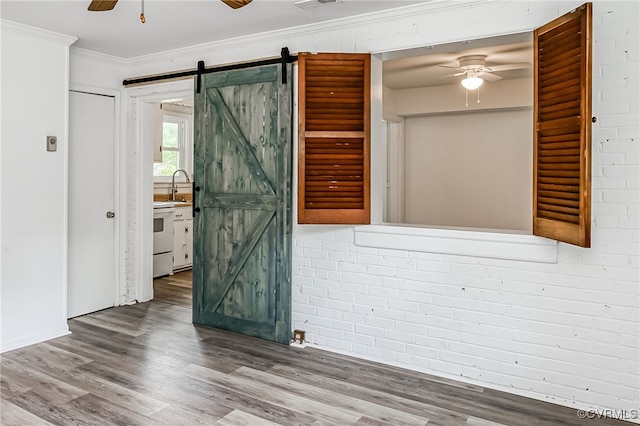 27 Medlock Rd, Sandston, VA 23150 - empty room featuring ceiling fan, a barn door, crown molding, a sink, and wood finished floors