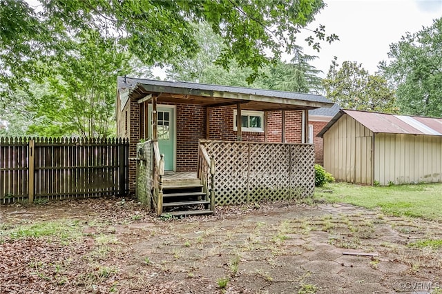 27 Medlock Rd, Sandston, VA 23150 - back of property with fence, a wooden deck, an outbuilding, a shed, and brick siding