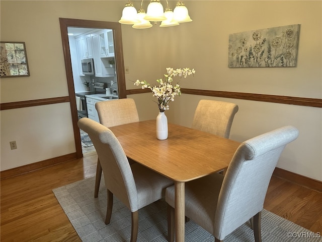 9079 Cudlipp Ave, Mechanicsville, VA 23116 - dining room featuring a chandelier, wood finished floors, and baseboards