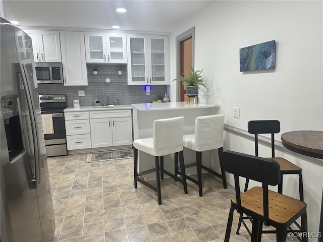 9079 Cudlipp Ave, Mechanicsville, VA 23116 - kitchen featuring appliances with stainless steel finishes, a sink, stone finish floors, white cabinets, and light countertops