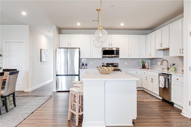 1900 Roseneath Rd Unit 9A, Richmond, VA 23230 - kitchen with stainless steel appliances, a center island, dark wood-style flooring, tasteful backsplash, and light countertops