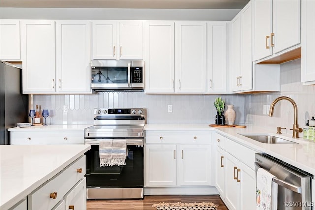 1900 Roseneath Rd Unit 9A, Richmond, VA 23230 - kitchen featuring appliances with stainless steel finishes, a sink, white cabinets, light countertops, and backsplash