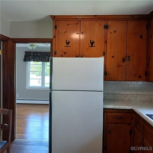 4846 Stanley Dr, Chesterfield, VA 23234 - kitchen with freestanding refrigerator, light countertops, backsplash, brown cabinets, and wood finished floors