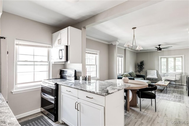 kitchen with stainless steel appliances, light wood finished floors, white cabinets, light stone counters, and crown molding
