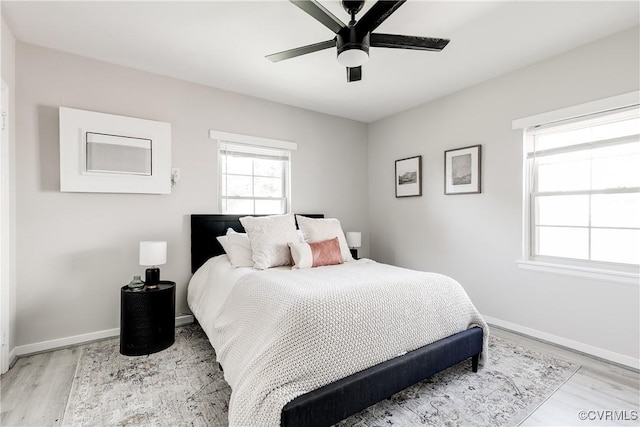 bedroom featuring light wood-style flooring, baseboards, and a ceiling fan