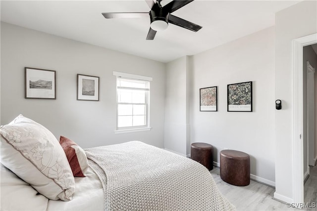 bedroom with light wood finished floors, baseboards, and a ceiling fan