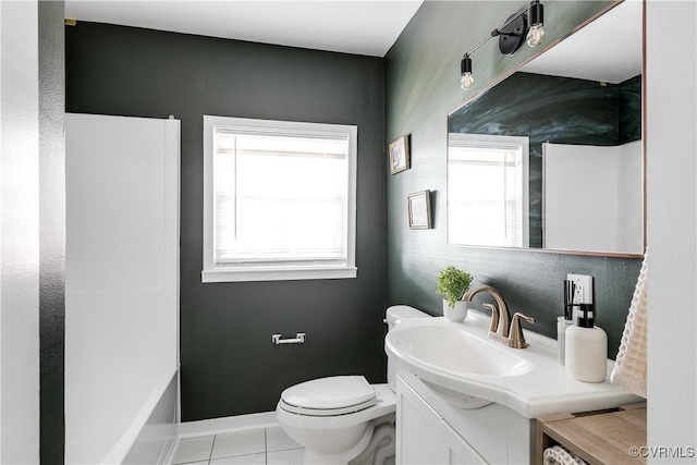 bathroom featuring toilet, vanity, baseboards, and a bath