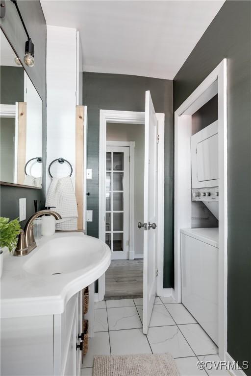 bathroom with stacked washer / dryer and vanity