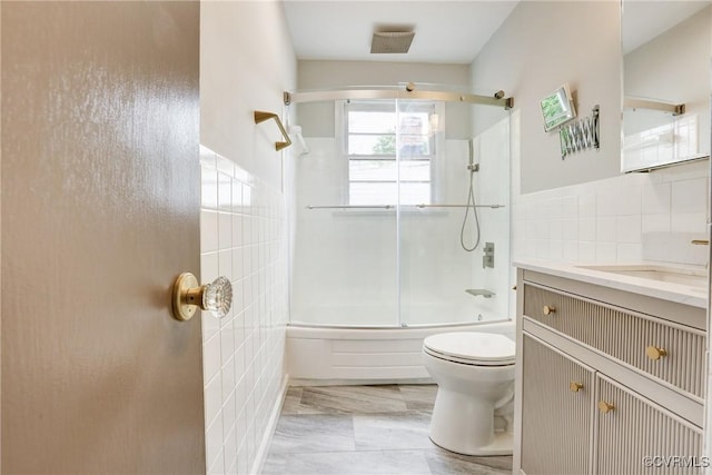 1909 N 28th St, Richmond, VA 23223 - bathroom with tile walls, toilet, shower / bath combination with glass door, and vanity