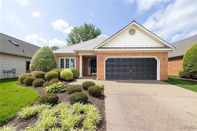 view of front of property featuring an attached garage, driveway, brick siding, and a standing seam roof