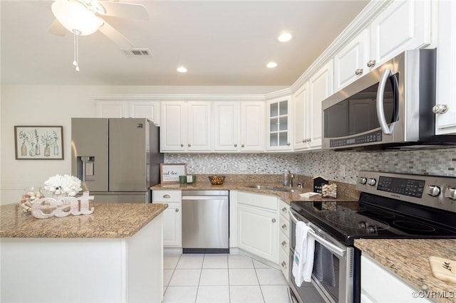kitchen featuring appliances with stainless steel finishes, a sink, white cabinetry, light tile patterned flooring, and recessed lighting