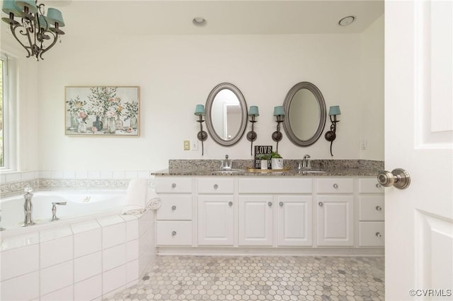 full bath featuring a garden tub, a chandelier, double vanity, and tile patterned floors