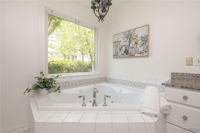 full bathroom with a whirlpool tub and a chandelier