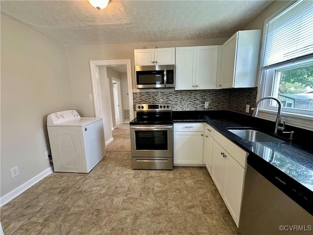 2404 Parrish St, Henrico, VA 23231 - kitchen featuring stainless steel appliances, washer / dryer, a sink, white cabinetry, and backsplash