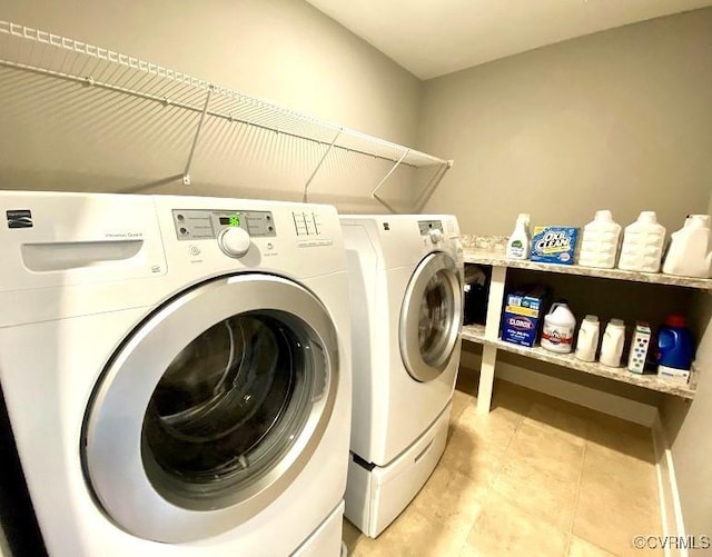 laundry area with washer and dryer and light tile patterned flooring