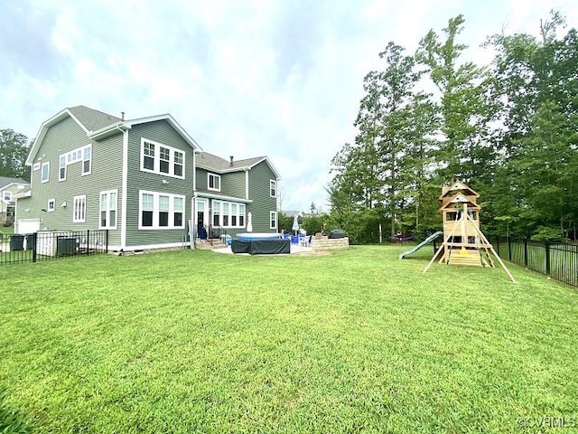 back of property with cooling unit, a pool, and a playground