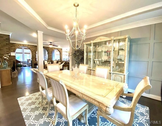 dining room featuring a tray ceiling, wood finished floors, a chandelier, ceiling fan, and crown molding