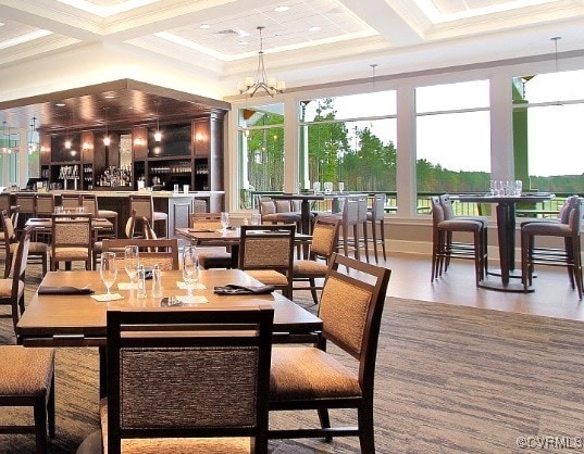 dining space featuring coffered ceiling, a chandelier, beamed ceiling, and ornamental molding