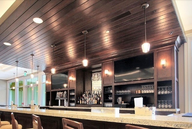 community bar area featuring wood ceiling and pendant lighting
