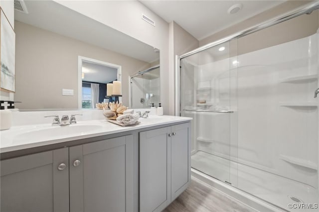 5904 Banyan Ln, Chesterfield, VA 23234 - bathroom featuring a stall shower, double vanity, and wood finished floors