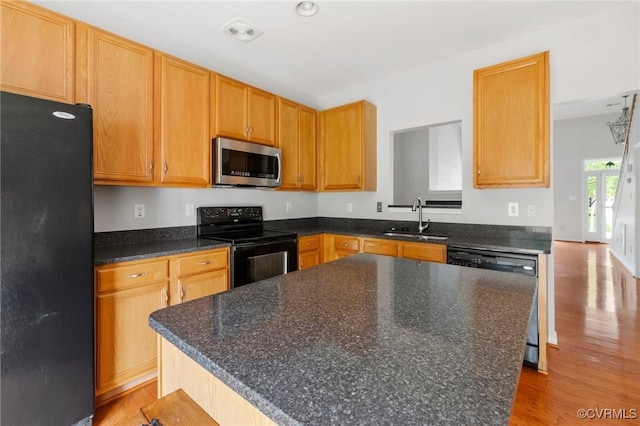 2409 Silver Lake Ter, Midlothian, VA 23112 - kitchen with black appliances, a sink, light wood-type flooring, and a center island
